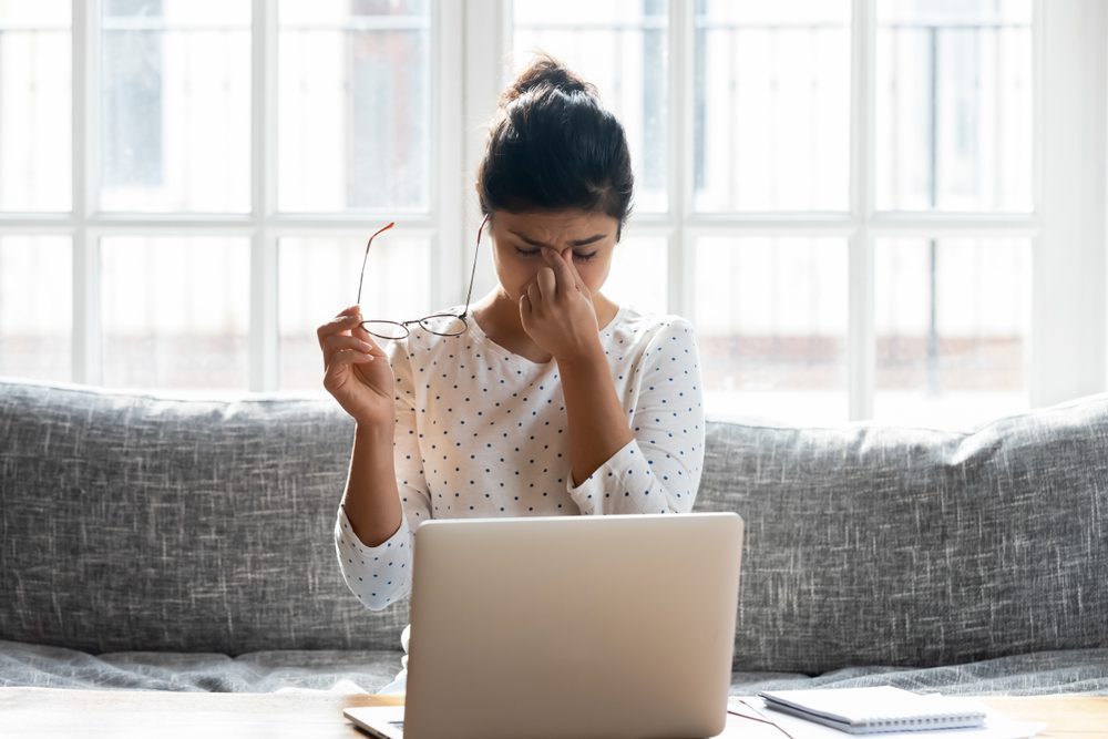 woman tries to work through her migraine