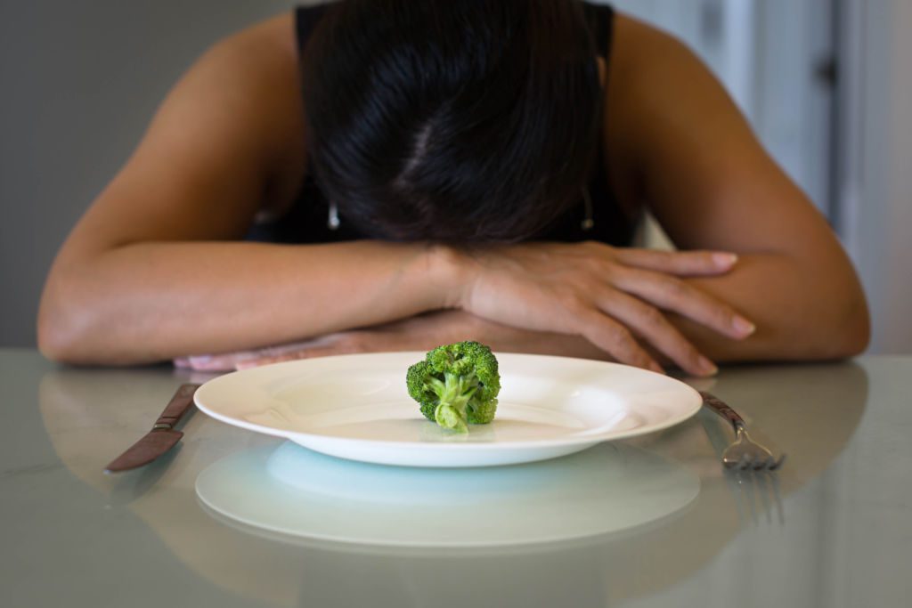 Depressed,Woman,Hungry,From,Dieting,,Sitting,In,Front,Of,A